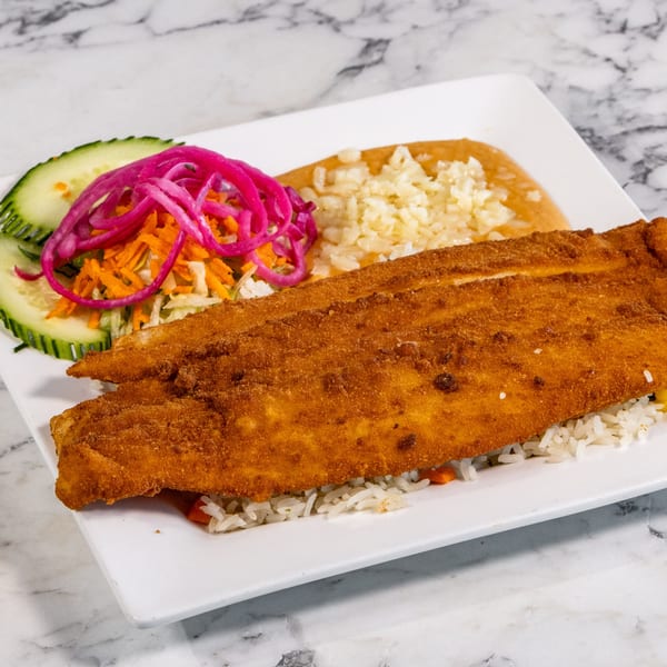 Fried fish fillet with rice, refried beans, pickled red onions, and cucumber slices on a white plate.